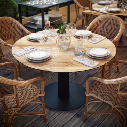 Table à manger ronde décor chêne clair Phénix sur une terrasse
